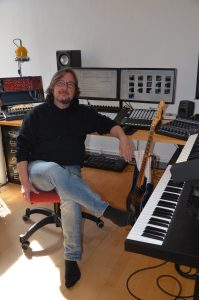 Ein Tonstudio zuhause mit Keyboard, Gitarre und Computer.